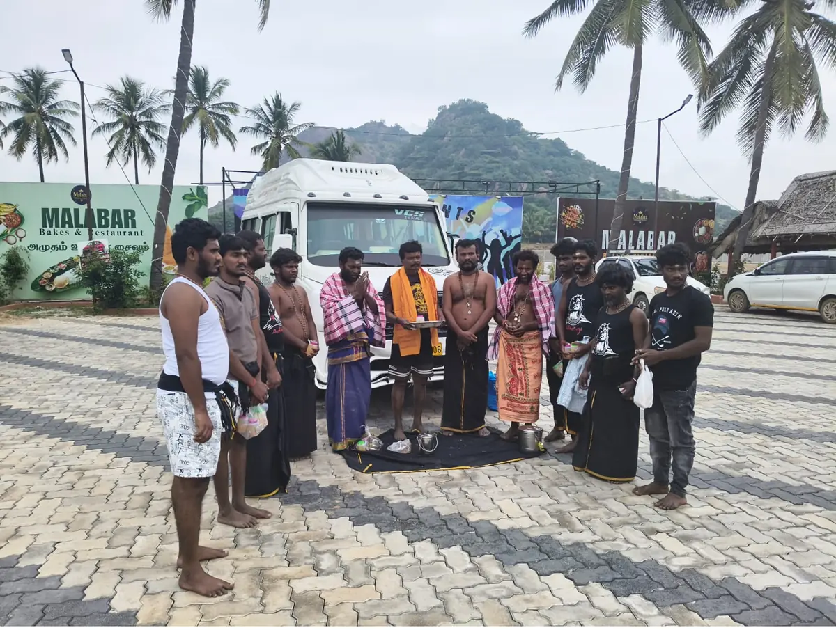Group tour beside a VCS Tempo Traveller